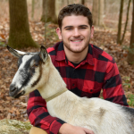 boy and goat in the woods