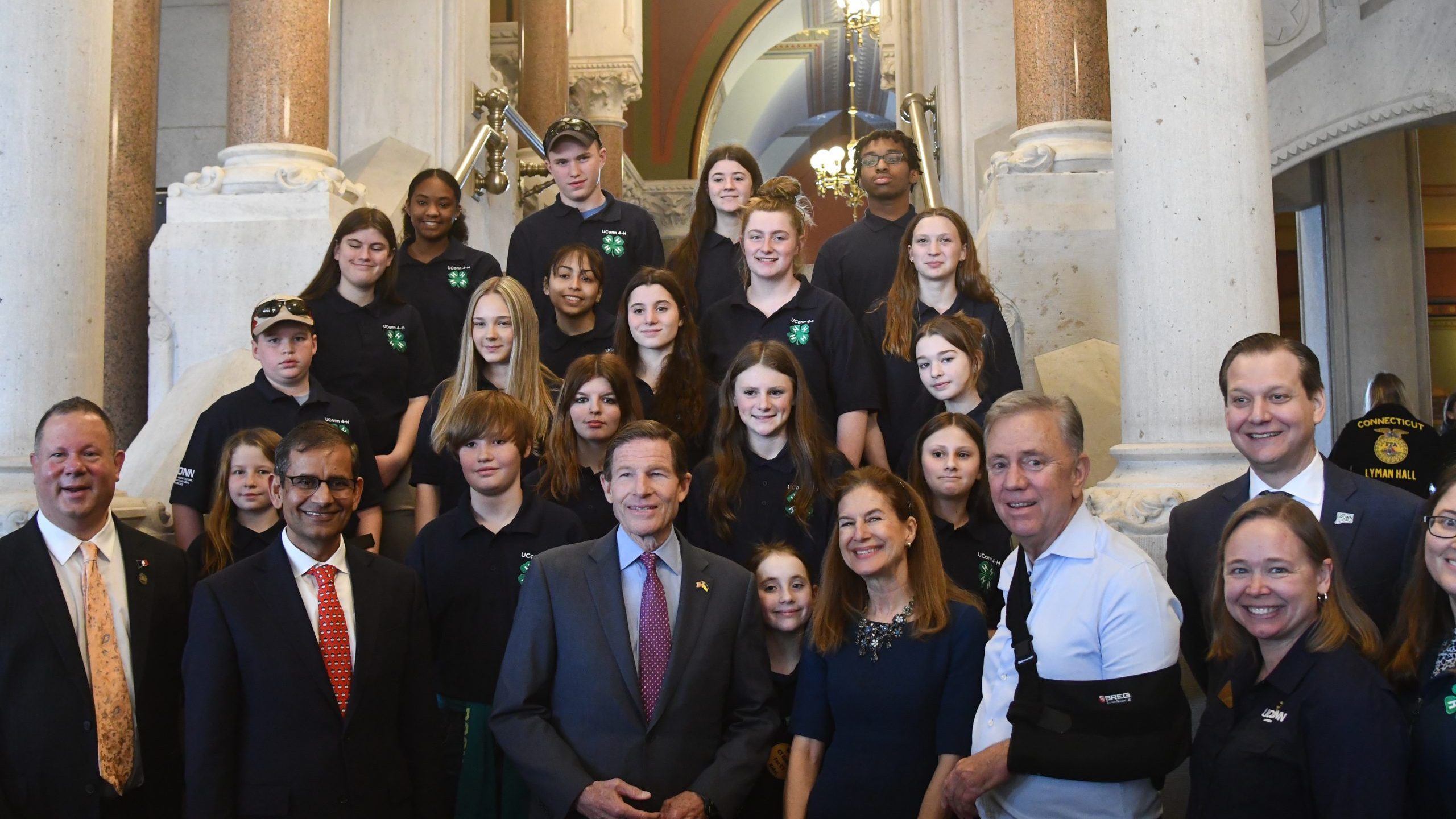Large photo of youth with elected officals and state extension staff