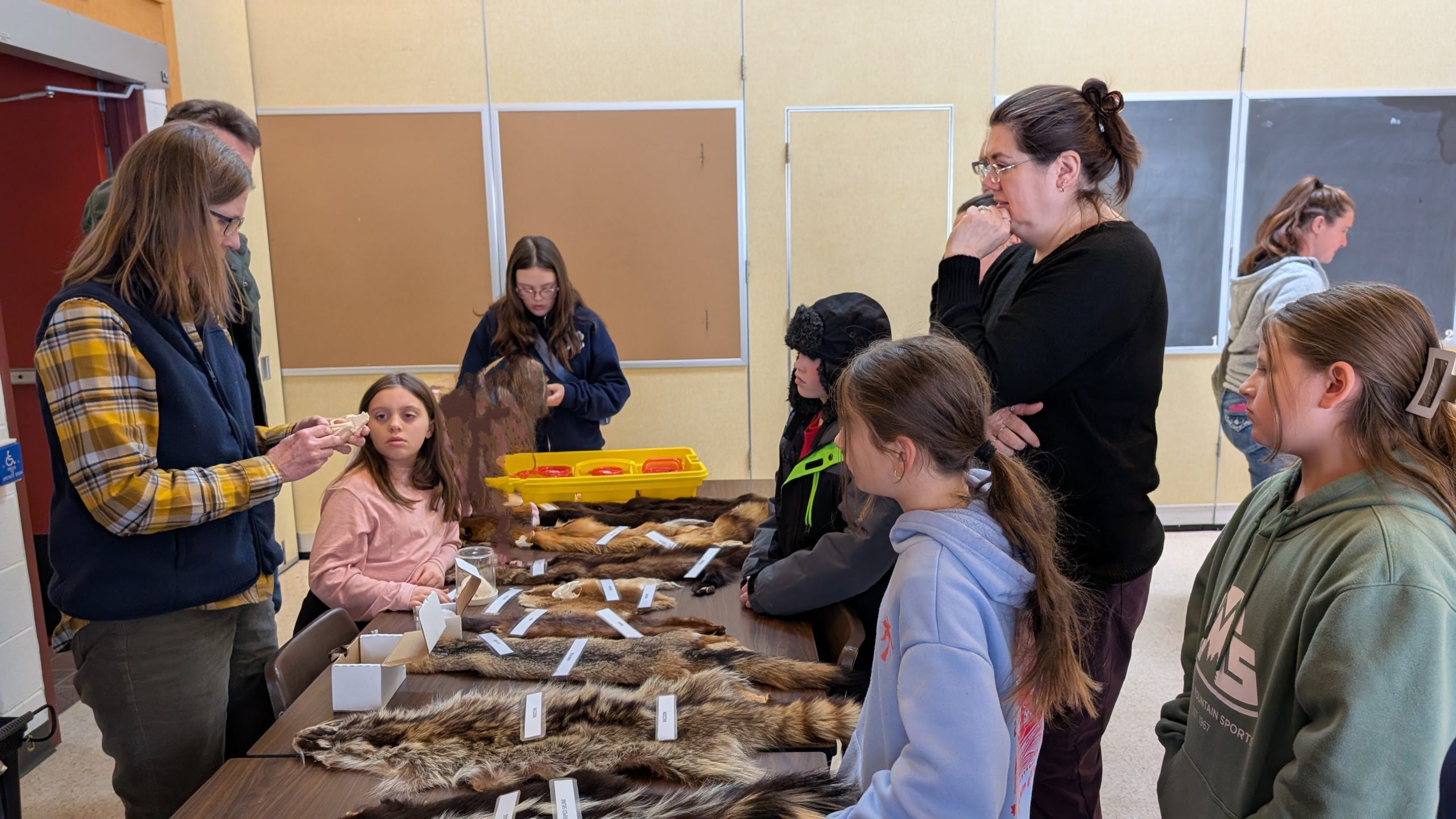 Youth listening to speaker with various items on table