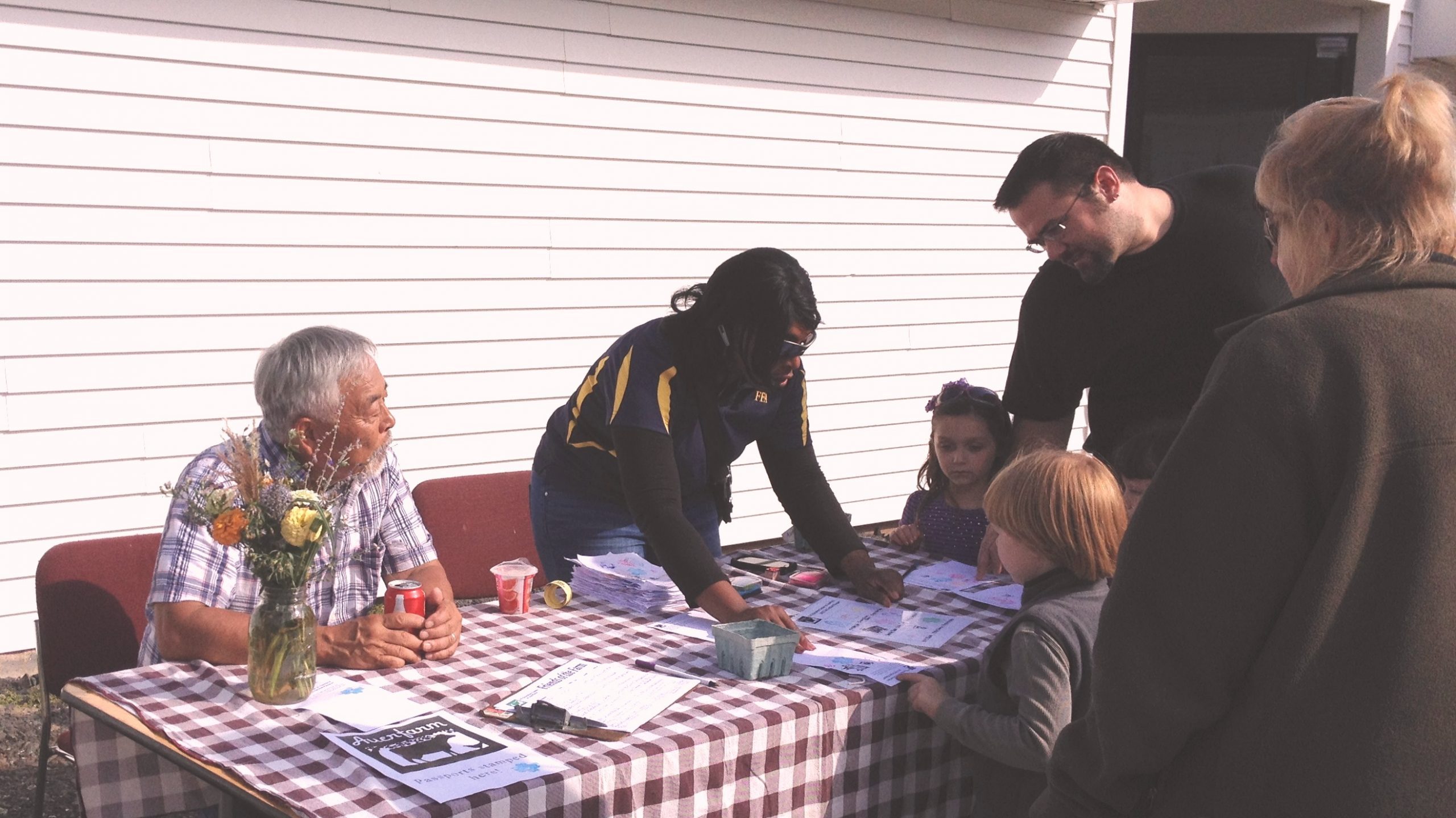 Women and men at a table with visitors listening in 