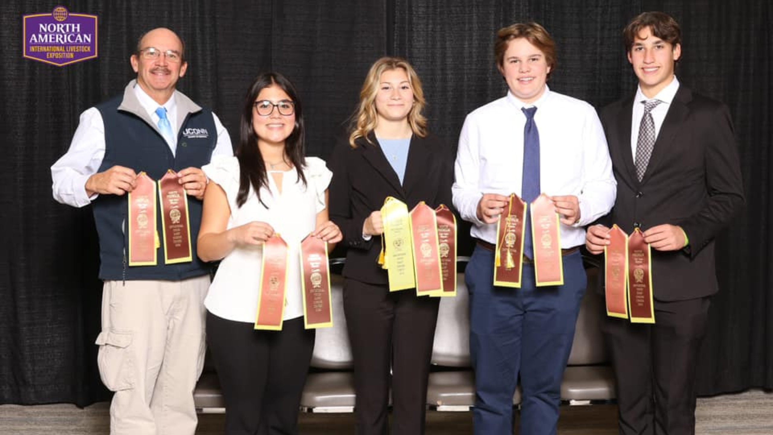4 youth and 1 adult holding ribbons from the National 4-H Dairy Judging Contest 