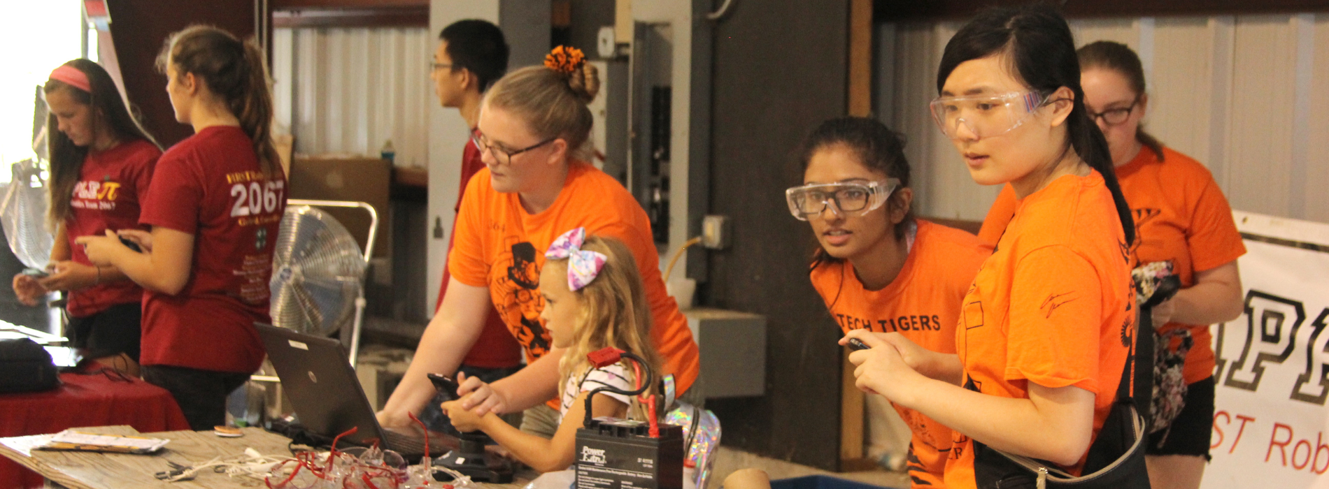 Group of girls with glasses and other protective equipment and next to electronics