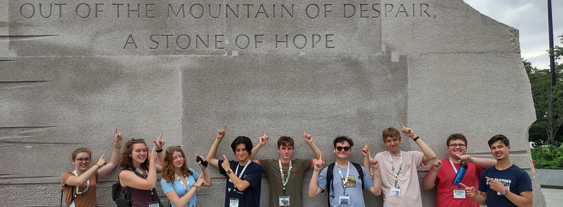 Group of youth standing under a monument in washington D.C.
