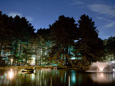 Lake with water fountain and stars above