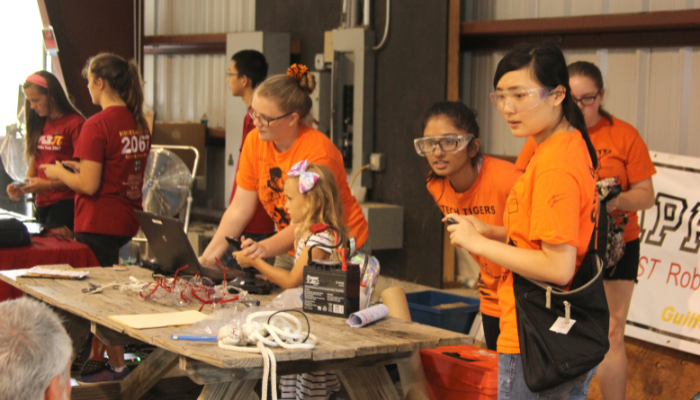 Group of girls with glasses and other protective equipment and next to electronics