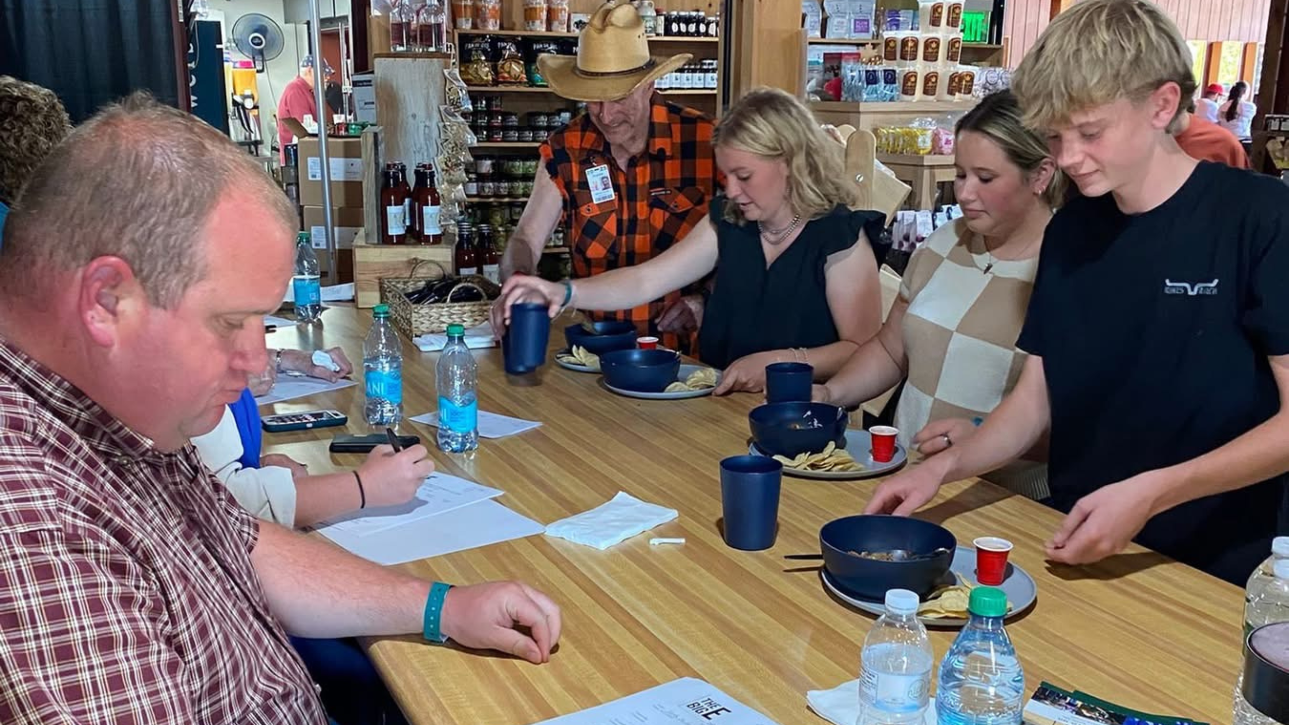 Table of youth and adults tasting food made by the youth at the Big E program