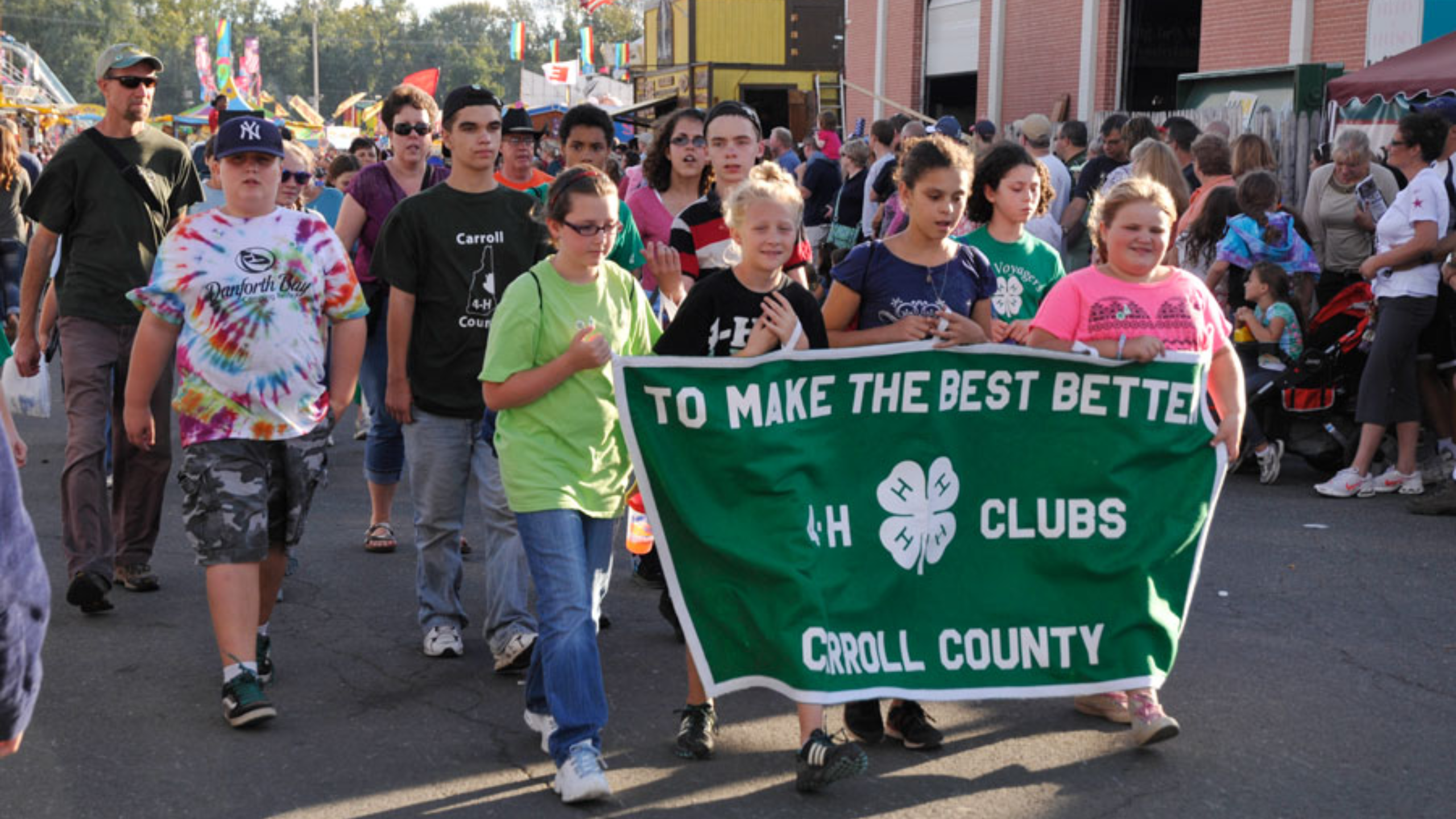 Crowd of youth holding a 4-H sign marching