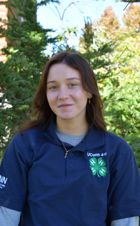 Girl wearing a blue shirt with a 4-H clover