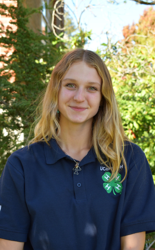 Girl wearing a blue shirt with a 4-H clover