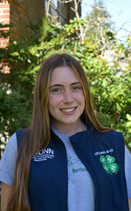 Girl wearing a blue shirt with a 4-H clover